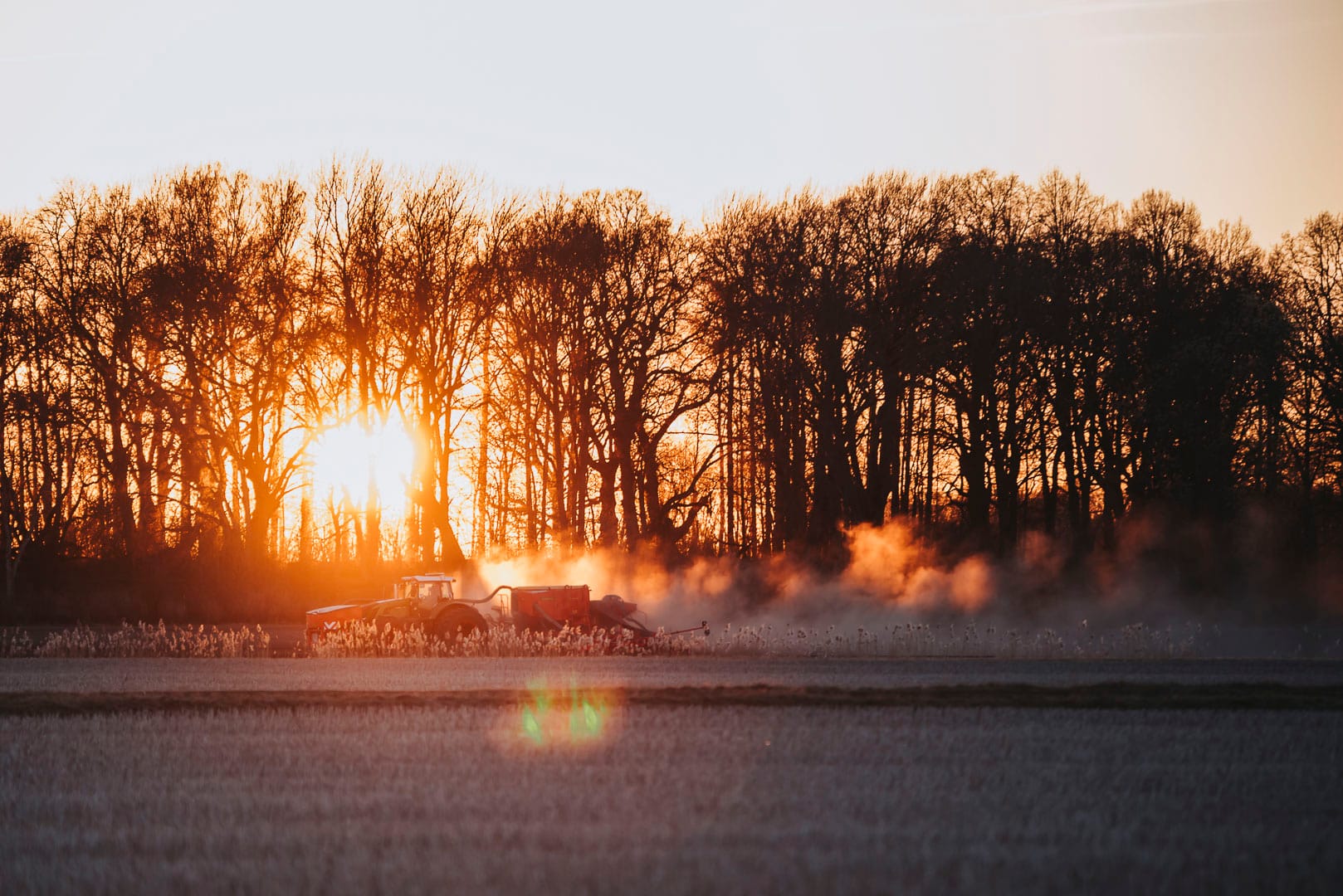 Traktor på gärde i solnedgång